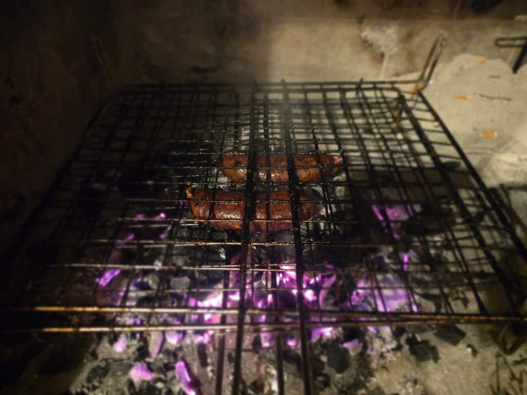 Fegatazze abruzzesi in cottura sulla brace - barbecue a carbone con fiamme violacee