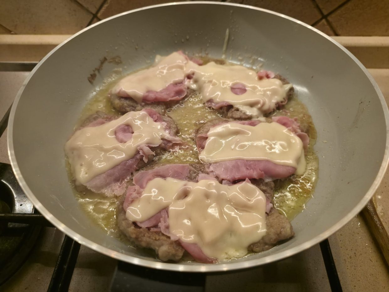 Scaloppine alla Valdostana cotte in padella con fontina filante e prosciutto cotto, servite alla Taverna Cinerini