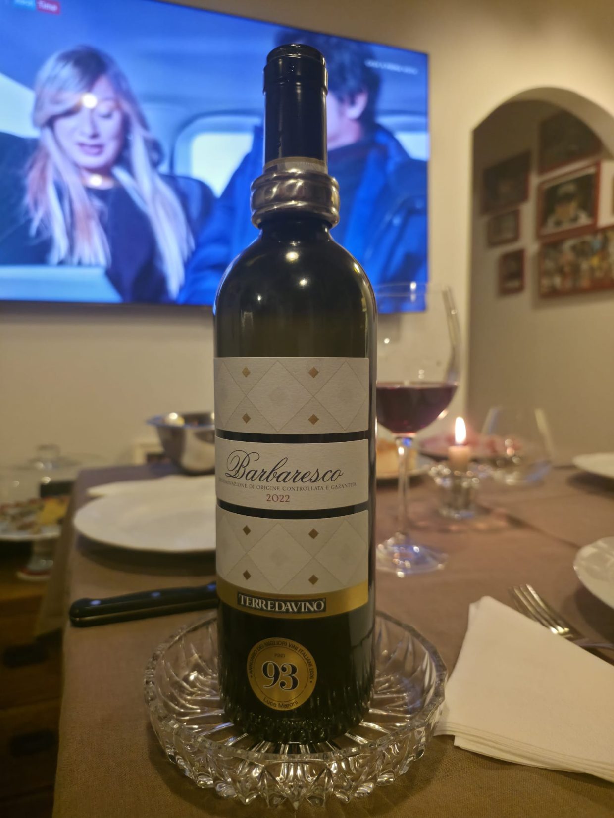 Bottiglia di Barbaresco 2022 Terre da Vino (Vite Colte) con calice versato e candela accesa